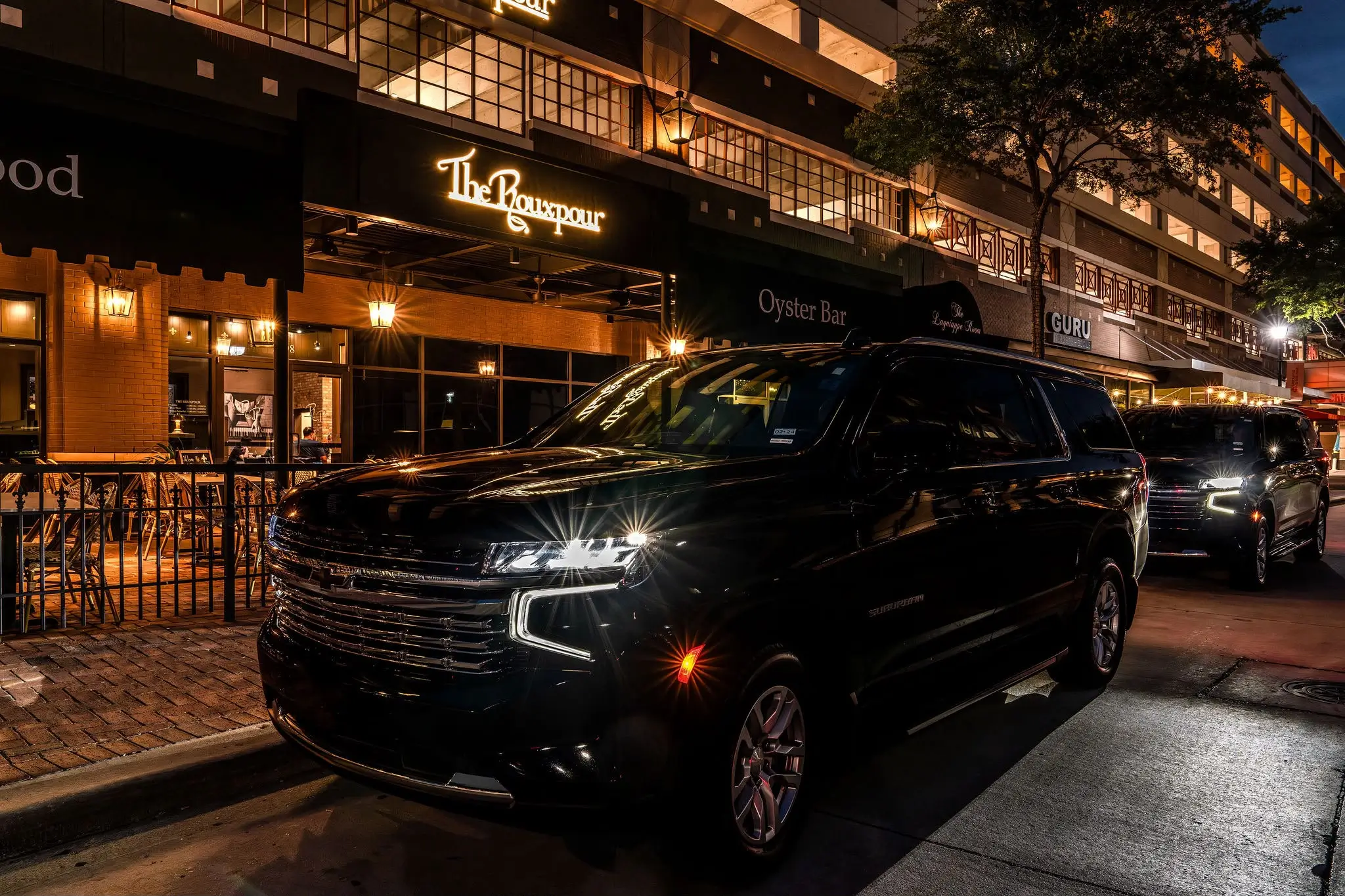 Black Sugarland XPRS SUV outside an illuminated restaurant at night